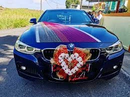 A blue BMW wedding car from Zohorul Rent-A-Car, the best car rental agency in Dhaka, Bangladesh decorated with a large heart-shaped floral arrangement.